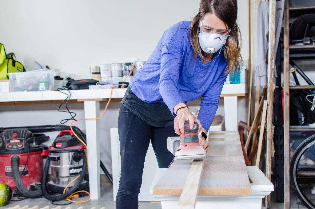 woman sanding slat wall boards