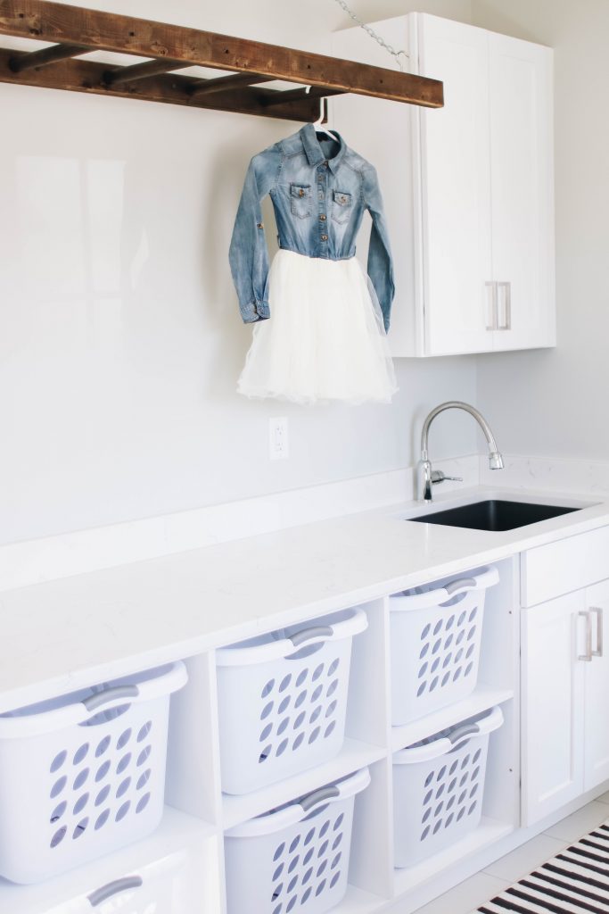 White Laundry Room design with cubbies for laundry baskers