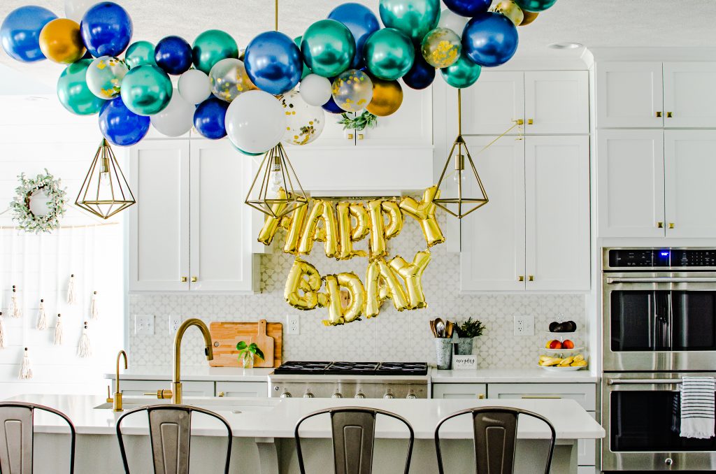 blue and green and gold balloon garland in kitchen