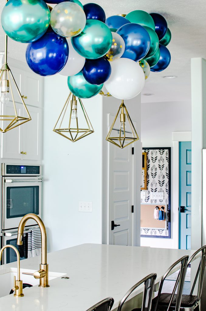 blue, green, and white balloon garland in kitchen