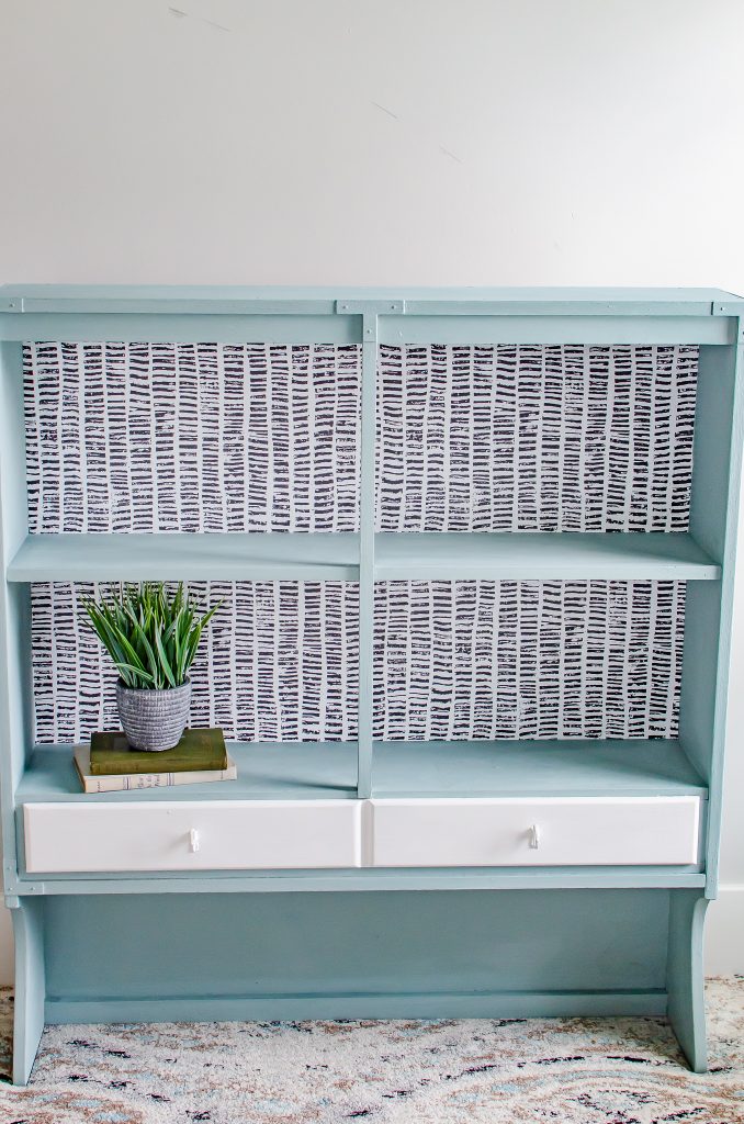 Modern wallpaper that is used inside a light blue cabinet.