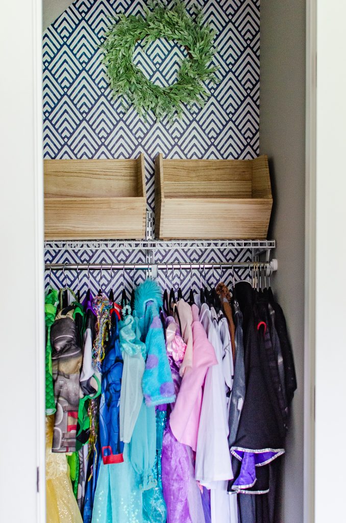 blue geometric wallpaper accent wall in a dress up closet for kids