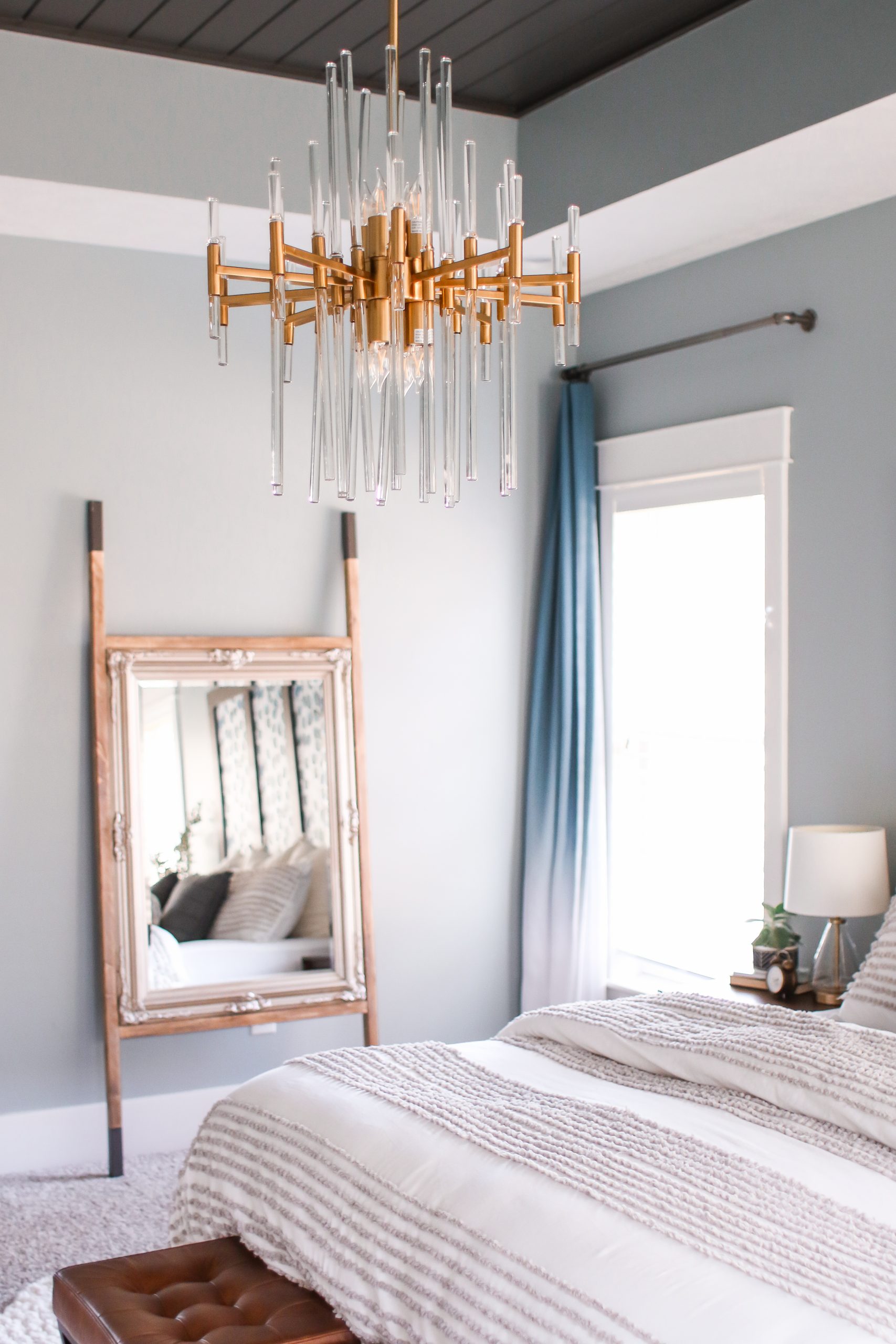 gold and glass chandelier in a master bedroom
