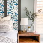 colorful wallpaper with board and batten frame with textured bed linens and a decorated wood end table