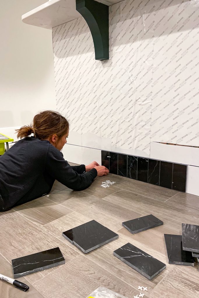 Laying the Nero Marquina tile on the back of the island with MusselBound