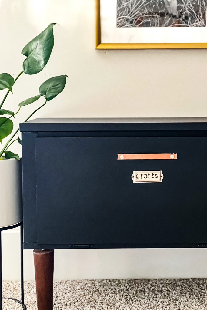 Playroom organization labels after. Wood Labels in metal label holder on a black storage cabinet.