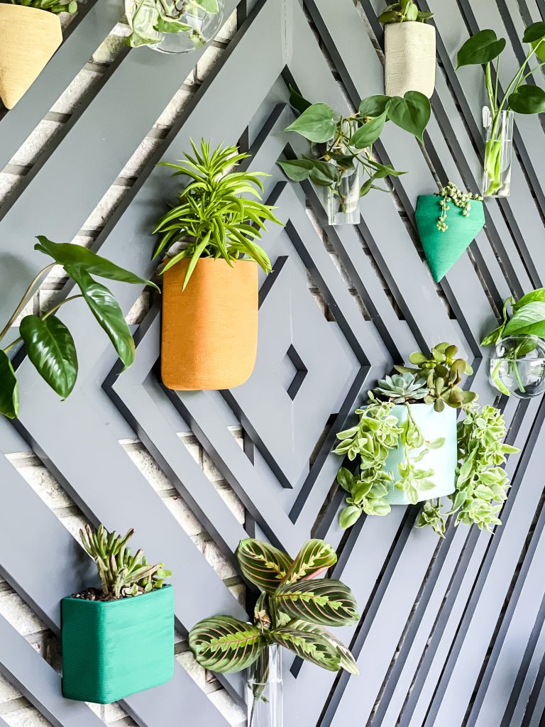 Colorful ceramic planters and glass hanging planters for succulents on a custom wood accent wall | HauteHouseLove.com