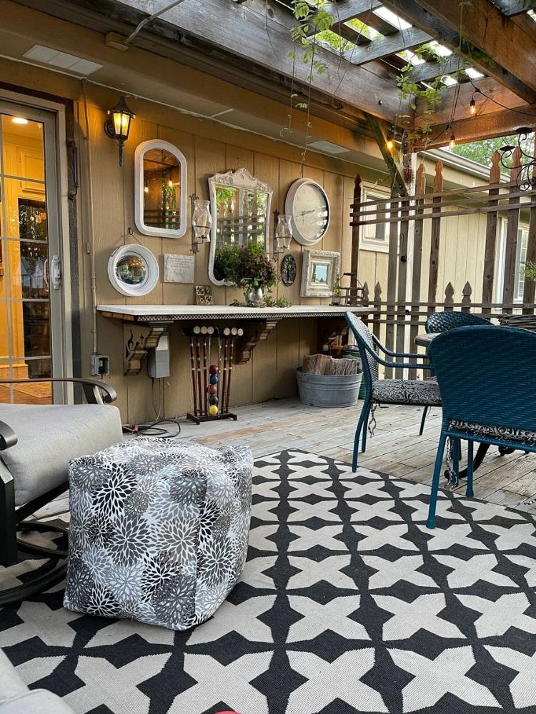 Outdoor patio with pergola roof with a wall of mirrors and a DIY pouf ottoman