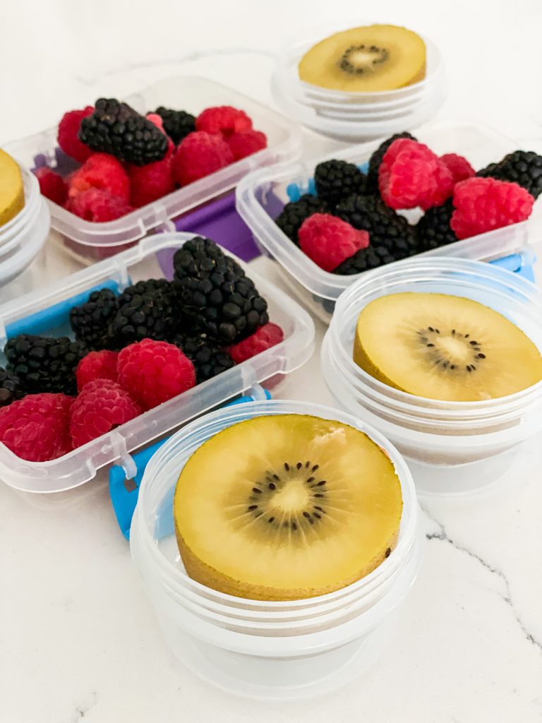 Fresh berries and kiwi in storage containers for lunch boxes