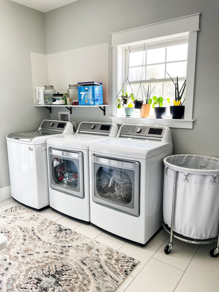 laundry room with one washer and two dryers