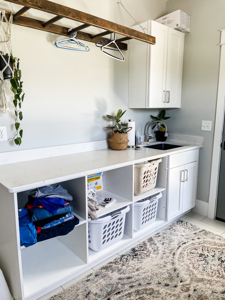 laundry room with storage cubbies and a hanging ladder for clothes
