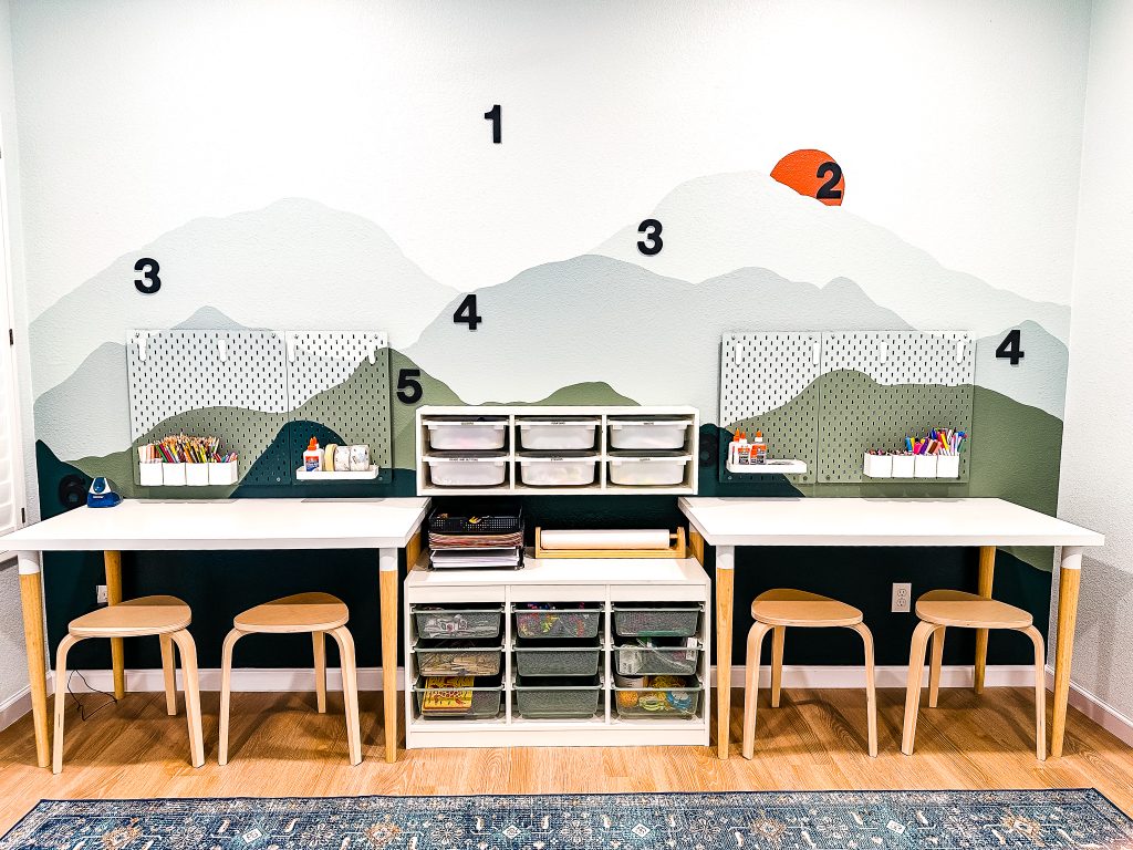 mountain mural accent wall with matte black house numbers, ikea craft tables and ikea storage